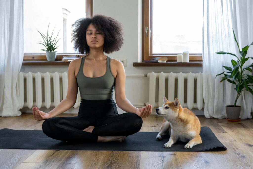 pexels-photo-4047042-4047042 Woman meditating on yoga mat with Shiba Inu dog indoors. Calm and serene home setting.