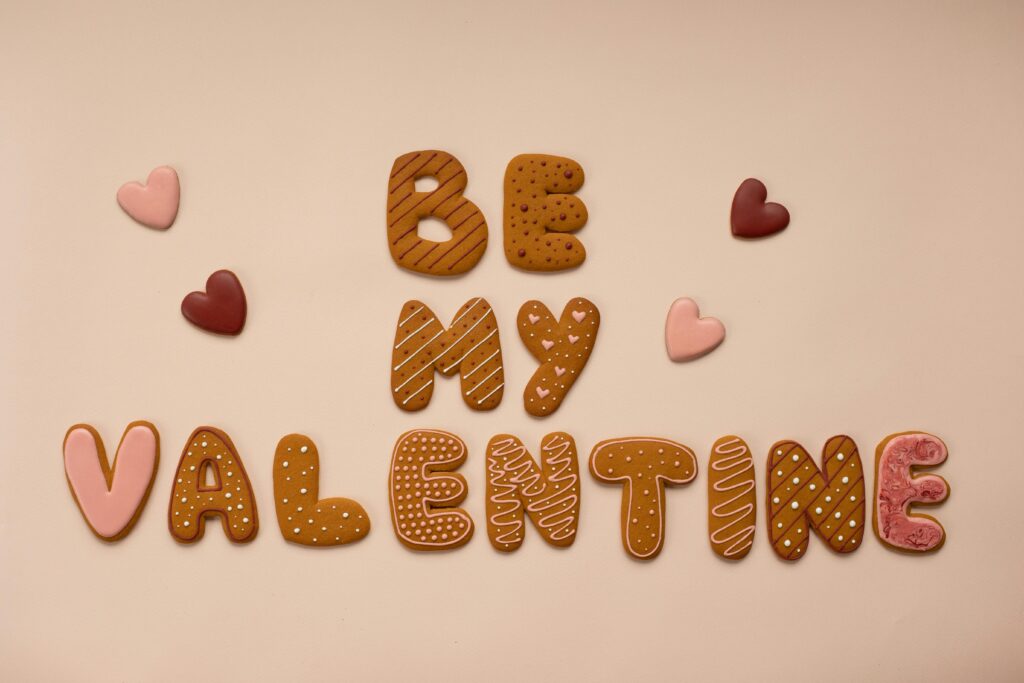 A delicious and creative display of heart-shaped cookies spelling 'Be My Valentine' on a beige background.